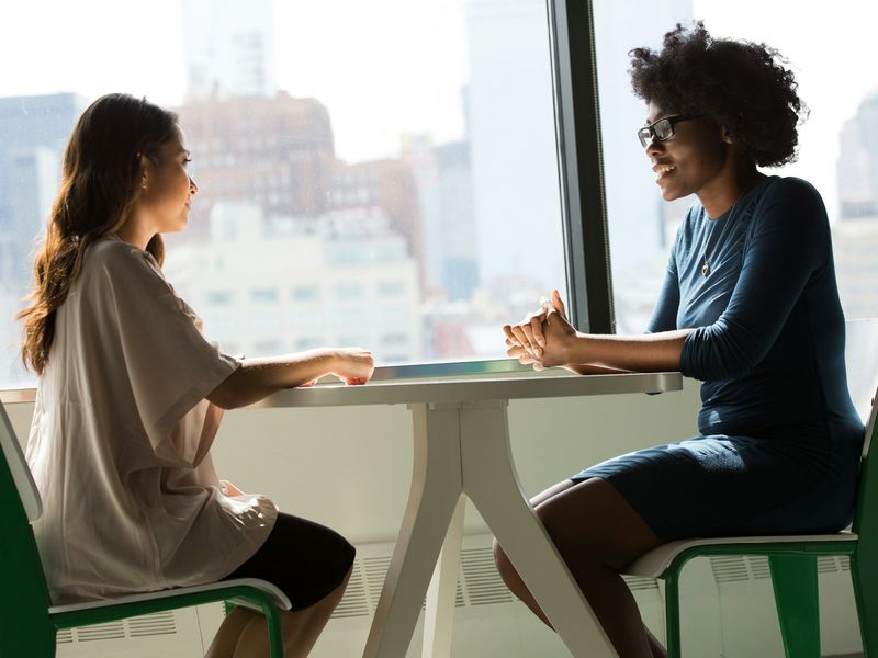 A therapist meeting with an adult patient in a consultation room